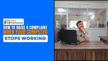 Person sitting at a desk with a laptop, looking confused, representing the situation when a computer stops working and the need to raise computer complaints.